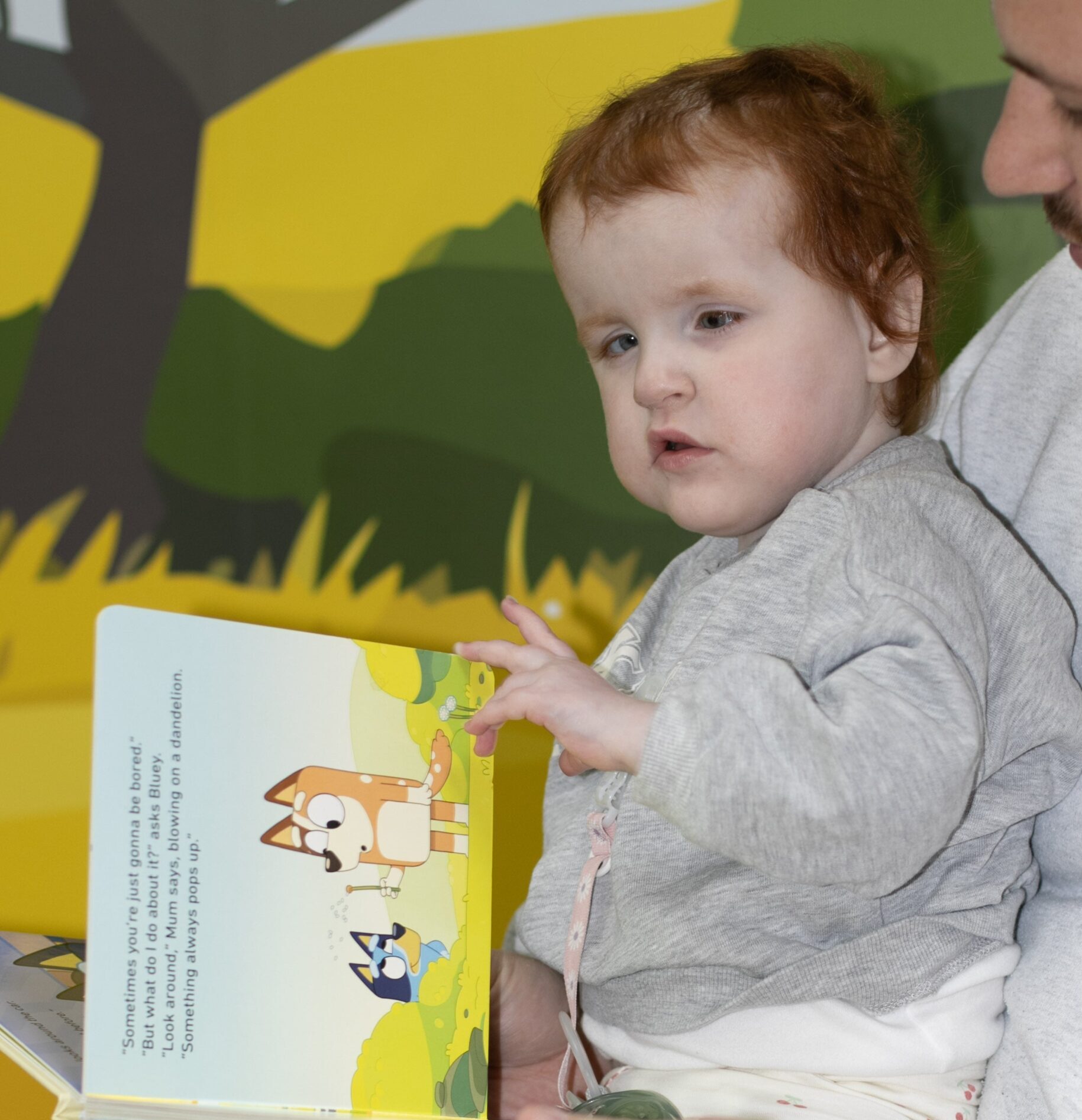 A young girl with cerebral palsy reading a book.